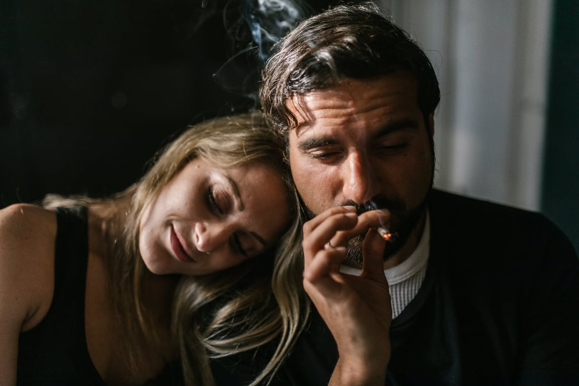 A Man Sitting Beside a Woman Smoking